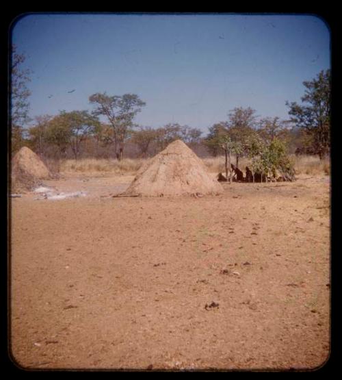 People sitting in the shade in Mukolovandi's kraal, seen in the distance