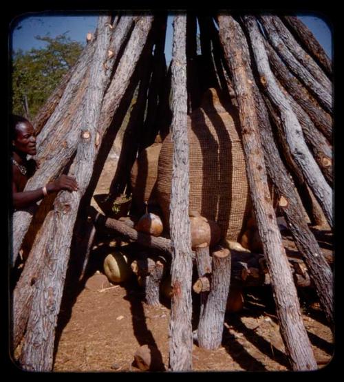 Mukolovandi standing by his storage hut