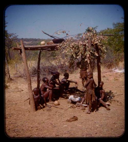 People sitting in shade and grinding mealies