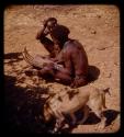 Kanakele playing chihumba, man sitting next to him