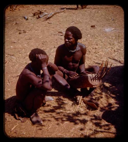 Kanakele playing chihumba, man sitting next to him