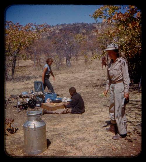 Andreas cooking; Elizabeth Marshall Thomas and Lorna Marshall standing  in expedition camp