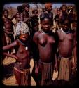 Group of people standing by a road, young girls standing in front, close-up