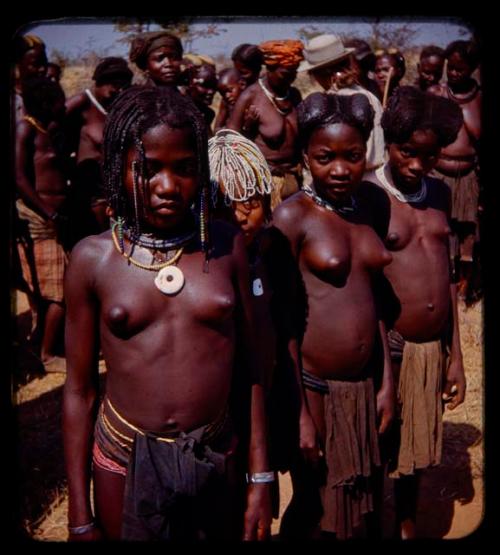 Group of people standing by a road, young girls standing in front, close-up