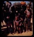 Group of people standing by a road, children standing in front, close-up