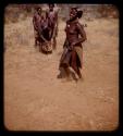 Woman dancing, people watching, and a boy playing a drum