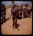 Woman dancing, people watching and clapping, and a boy playing a drum