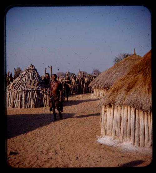 Woman walking between huts