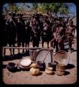 Women and children standing in a line in Vahinga Kraal with a pile of bowls in front