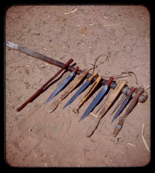 Knives, sheaths of wood, and awls on a stick