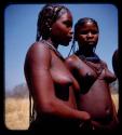 Two women standing, showing scarification on one woman's arm