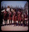 Women and children standing in a line in a kraal