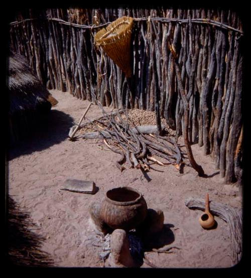 Pot with a fire under it by a fence