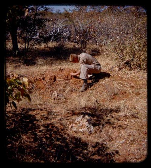 John Marshall crouched and looking at the ground