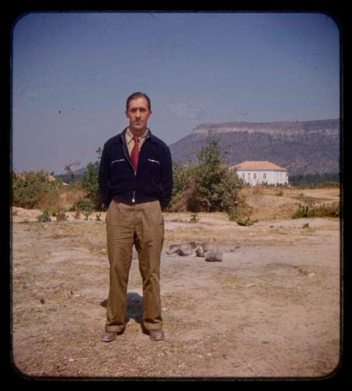 Senhor Duarte standing, house in the background