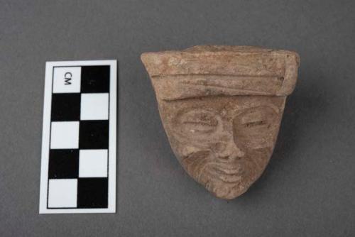 Pottery figurine head-tattoo-like markes on cheeks