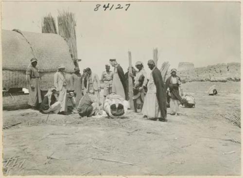 Life scene close shot of group of men with house in the background