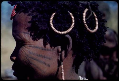 Ornament: Bau of Band 10, close-up showing copper rings in her hair, red ornament of store beads, copper bead earring and scarification