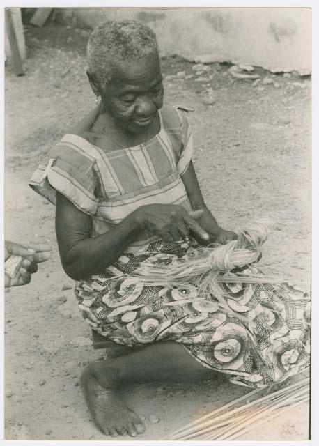 Woman sitting on the ground looking at fibers