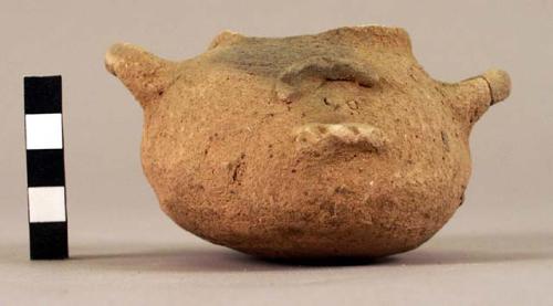 Crude shoe-shaped, 2-handled pottery vessel. Plain ware.