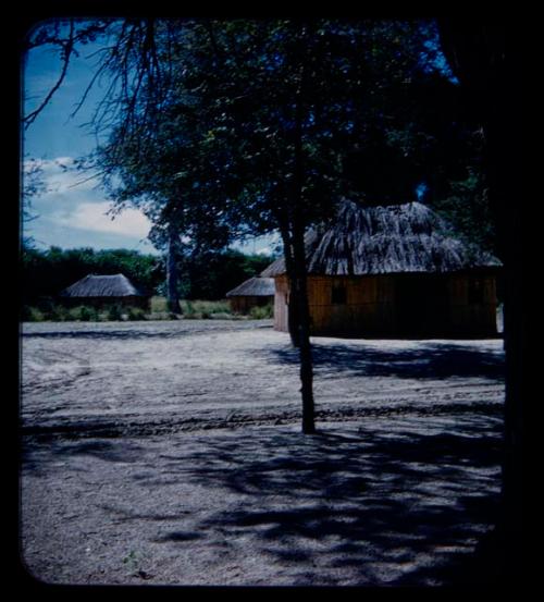 Three huts, in the distance