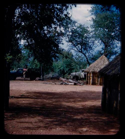 Huts, trucks in the distance