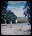 Expedition members standing at bank of a river