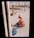 Woman sitting on ground near building