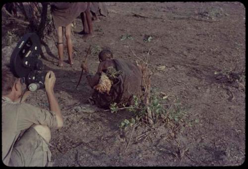 Woman digging with a digging stick, being filmed by John Marshall