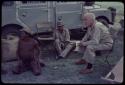 "Gao Medicine" sitting with Laurence Marshall and another man in front of the expedition Land Rover