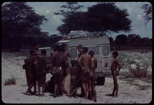 Group of people standing with John Marshall next to the expedition Land Rover