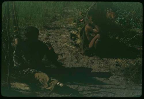 "/Qui Hunter" sitting, with a woman sitting behind him