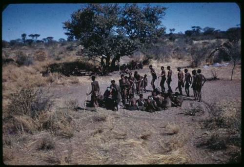 Dance: //Khuga dancing with a line of men around a circle of women sitting at the beginning of a dance, with little boys following "Gao Medicine" (copy of slide 7B-75)