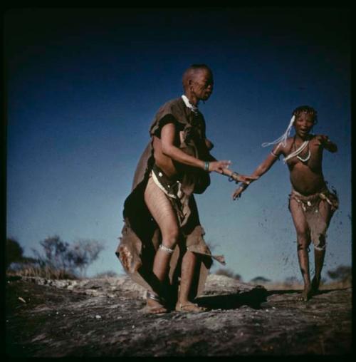 Dancing, Women dancing: !U without her kaross, dancing with !Ungka on the ledge by a waterhole (copy of slide 9C-29)