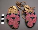 Pair of child's moccasins, skin with beaded uppers and painted soles. beads are