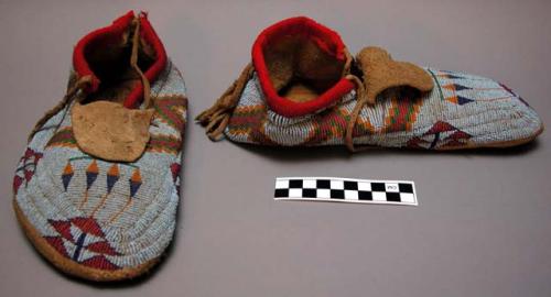 Pair of moccasins--beaded pattern on top, fringe at heel.