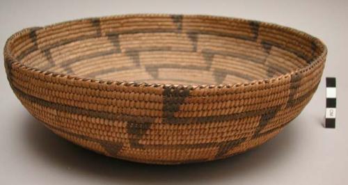 Round shallow basket, coiled. Geometric designs.