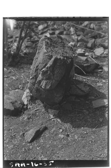 Human face carved in round in same court as carved stone figure