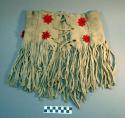 Girl's fringed skirt, kilt or apron of buckskin ornamented with rosettes of red cloth with pinked edges & beads in centers.