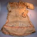 Woman's long sleeved dress, fringed. Made of buckskin tanned with alder bark.