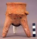 Pottery tripod jar (1 leg missing) with 2 effigy heads on side.  Light brown, pr