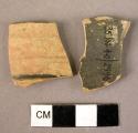 2 potsherds - thin ware with remains of black glaze