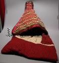 Cradle top of red cloth with black stripes, shell and bead trimming