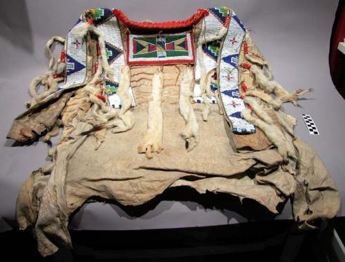 Shoshone shirt. Hide w/ flannel around collar, beading, ermine skin.