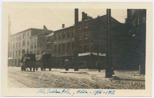 Photograph of a street with carriages and buildings