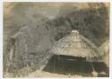 Thatched roof structure in front of a mountain