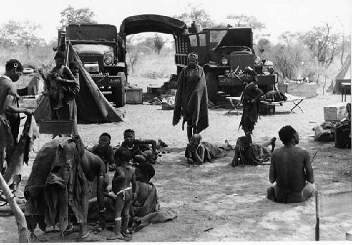 Group of people gathering before the two expedition GMC trucks
