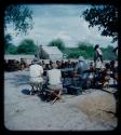 Expedition: Group of people and expedition members gathered at the campsite, with interpreters talking