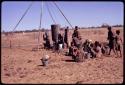 Group of people waiting for water to be poured at a government borehole