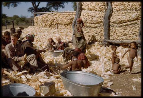 Expedition, Metzger: Group of women and John Marshall husking corn